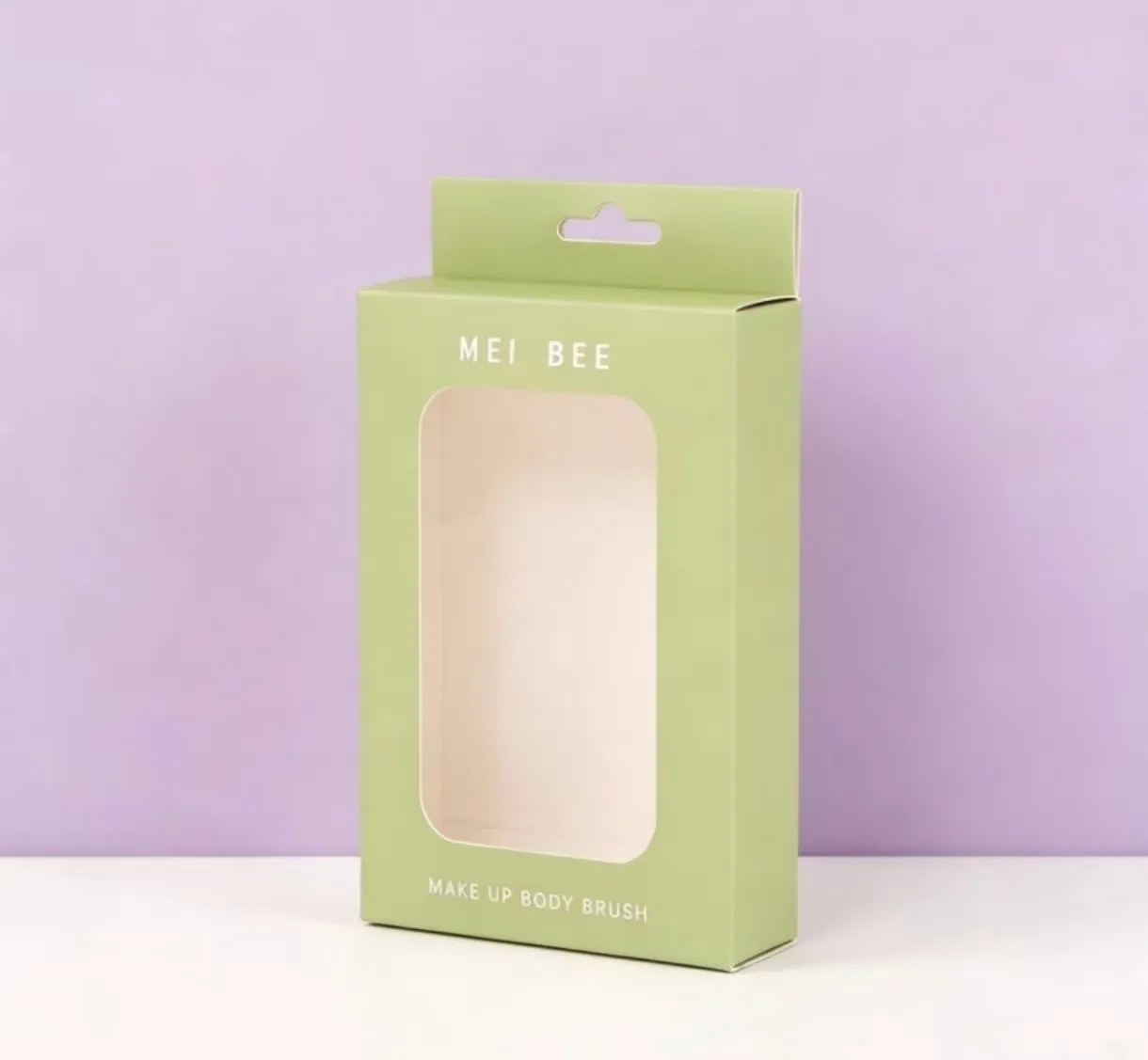 Green printed color box with a die-cut window and hang tab, made for a makeup body brush